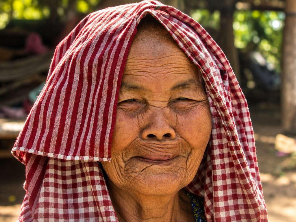 Portrait d’une habitante âgée, la tête couverte d’un krama rouge